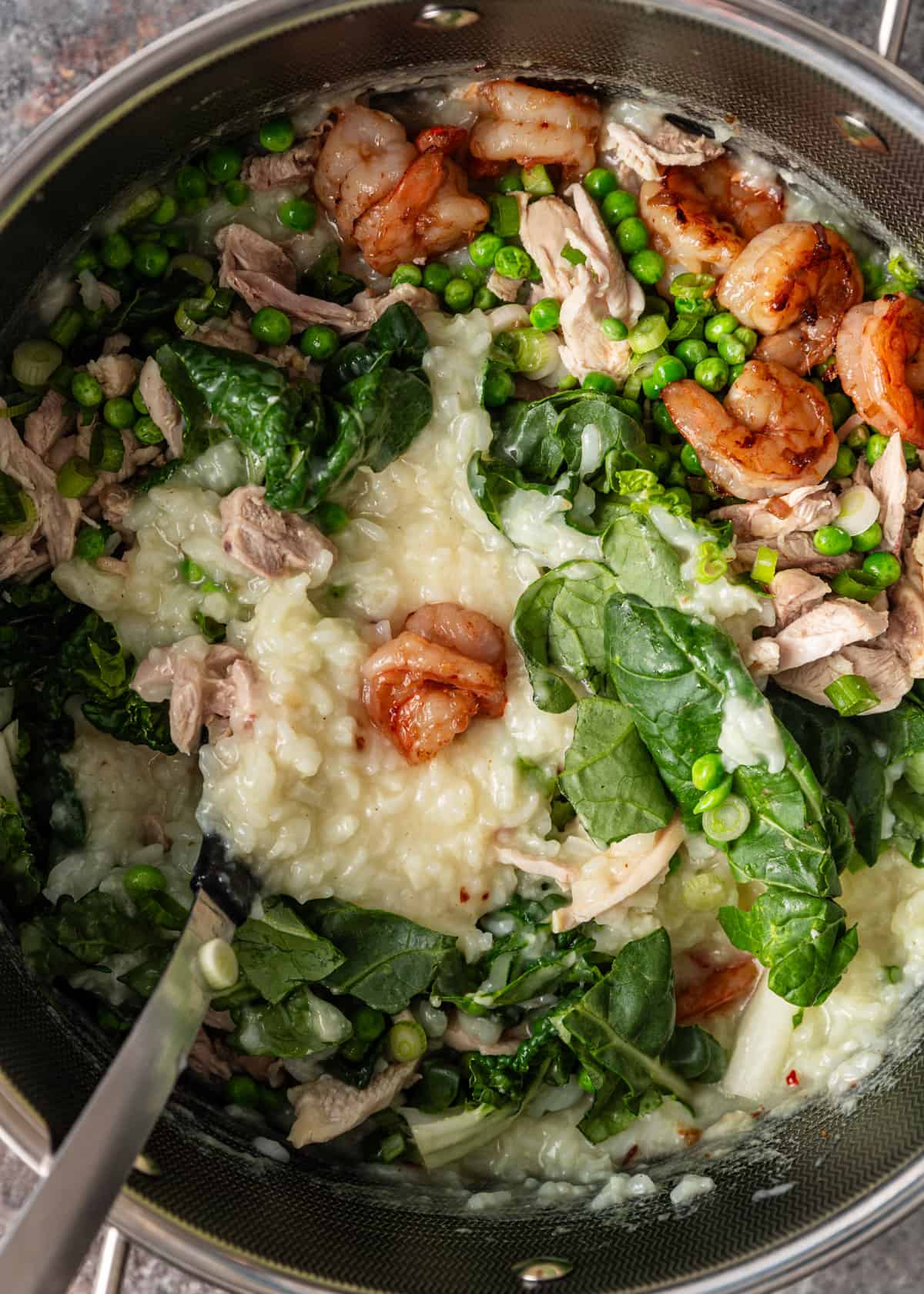overhead: assembling shrimp and chicken congee in a pan
