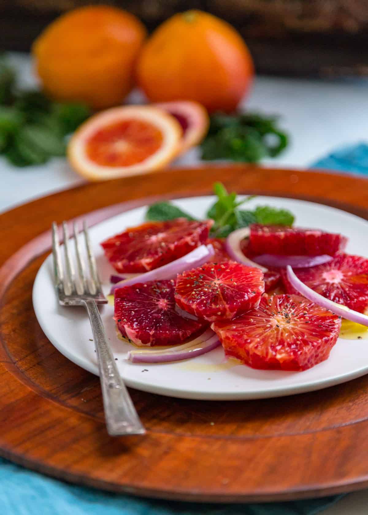 my blood orange salad recipe on a white plate with a fork