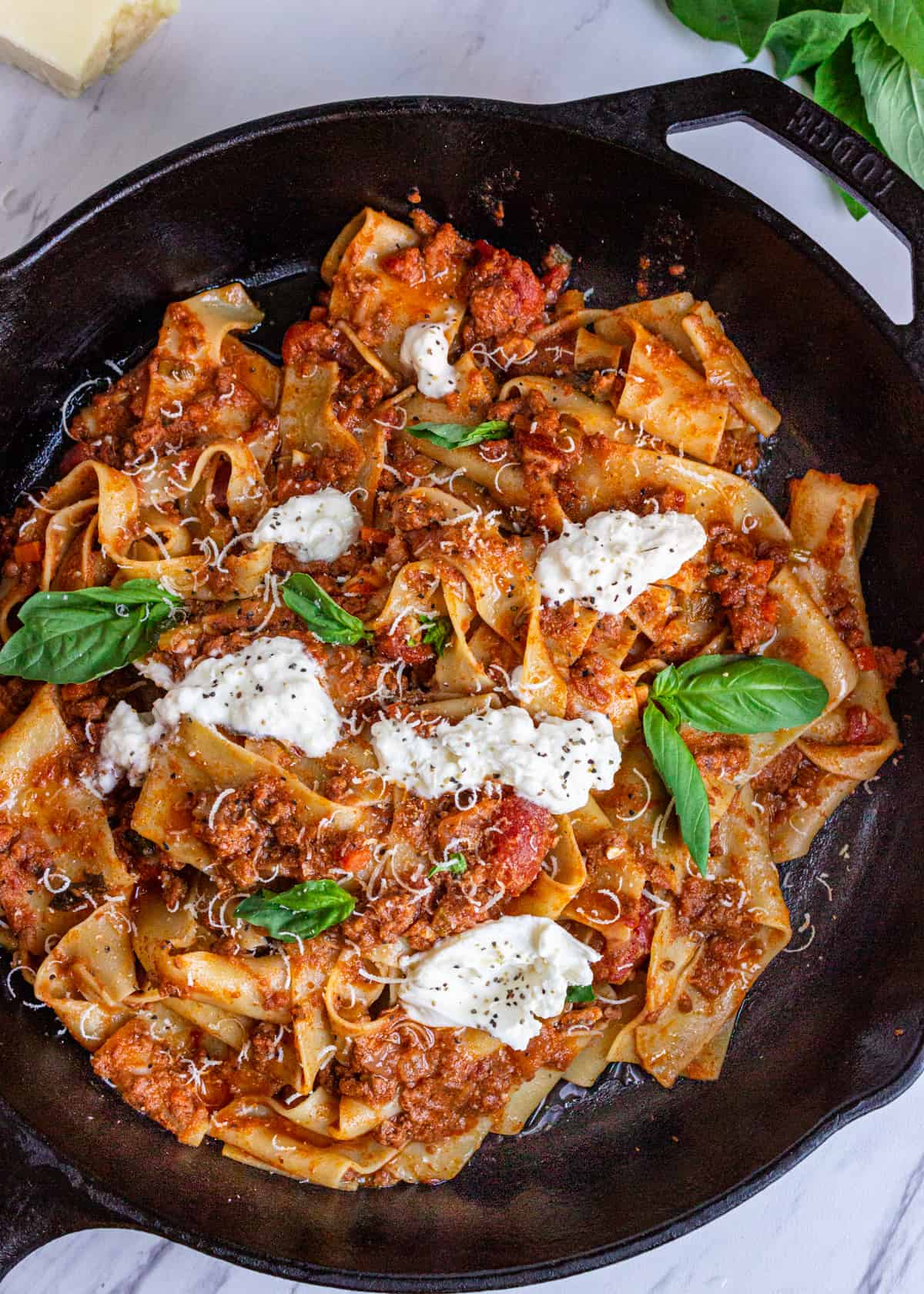 overhead: my tagliatelle bolognese recipe with burrata and fresh basil on top