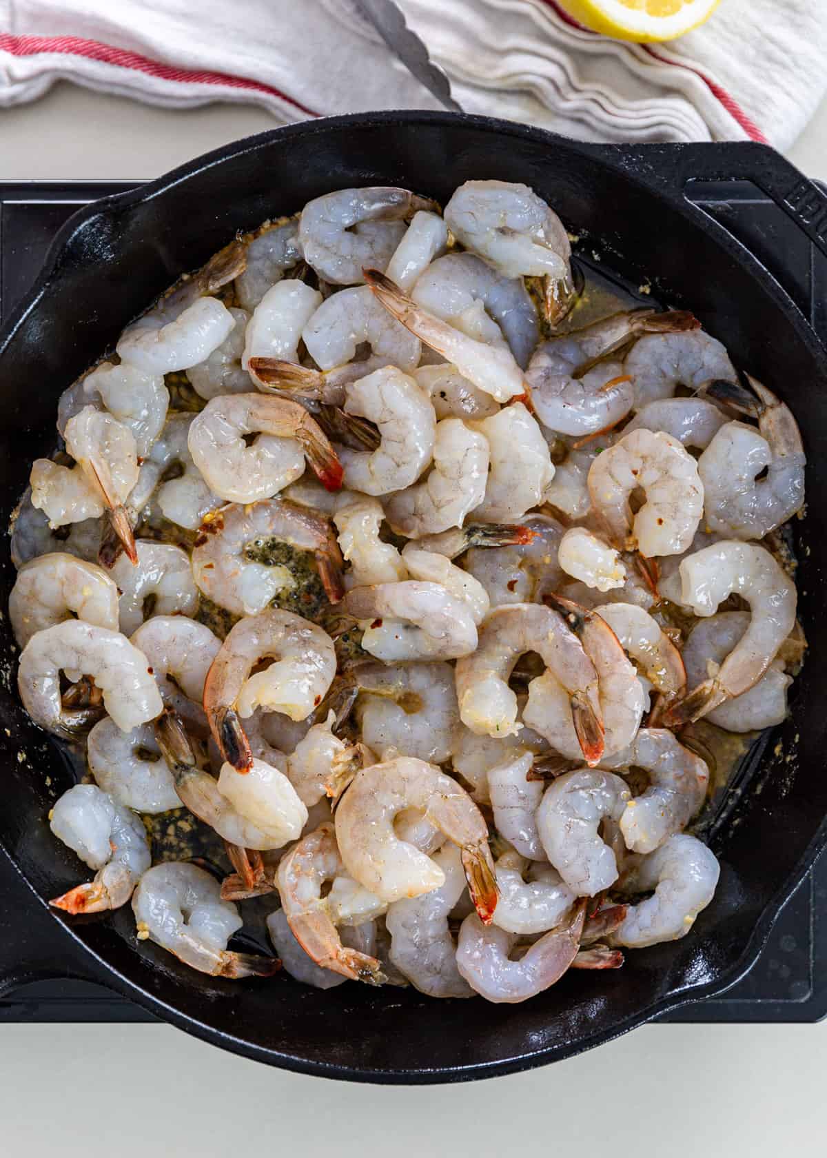 overhead: shrimp added to sautéed garlic in a pan