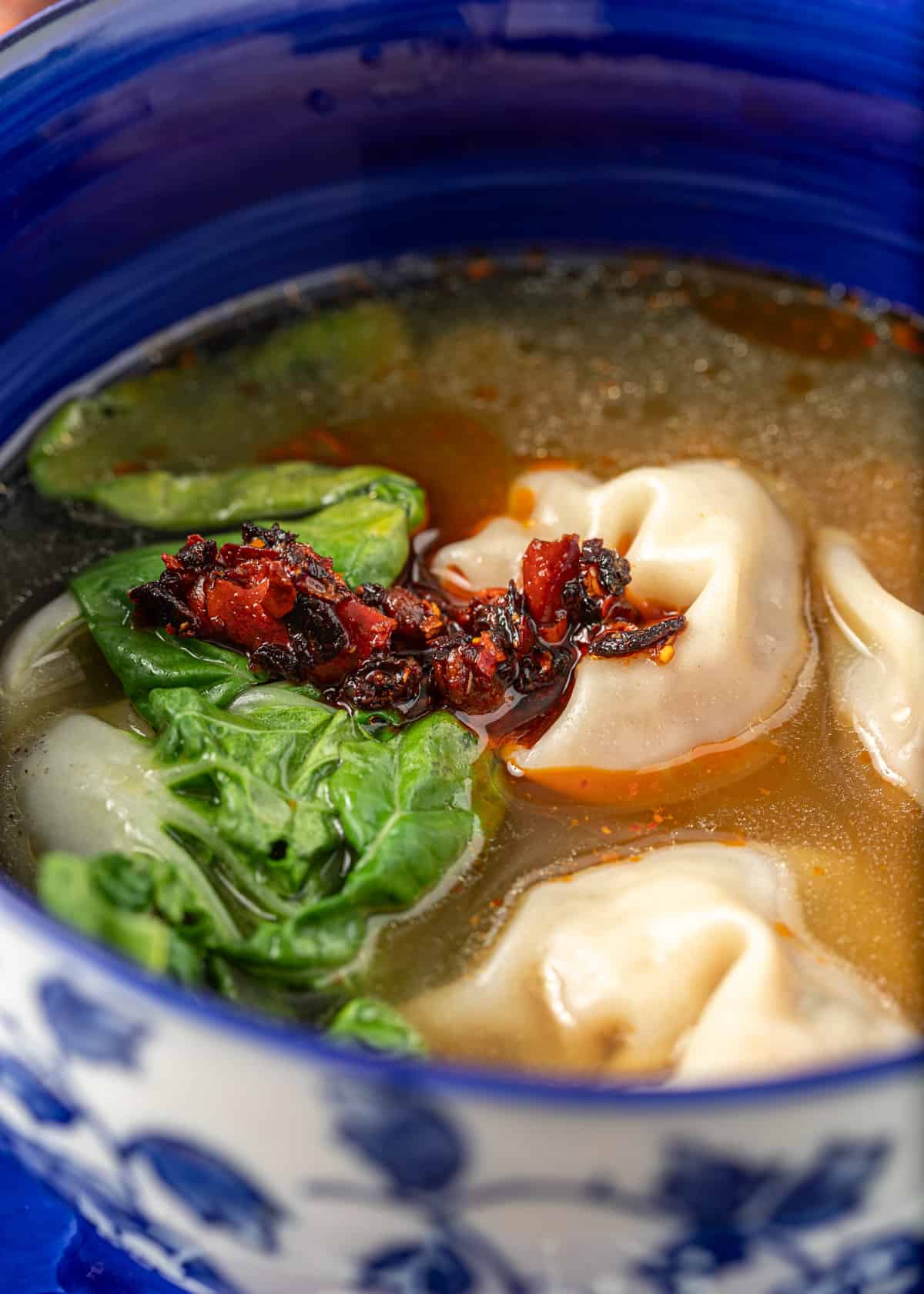 extreme closeup: wonton soup with chili paste and bok choy on top